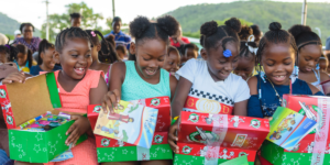 A group of girls opening their Operation Christmas Child gifts excitedly.